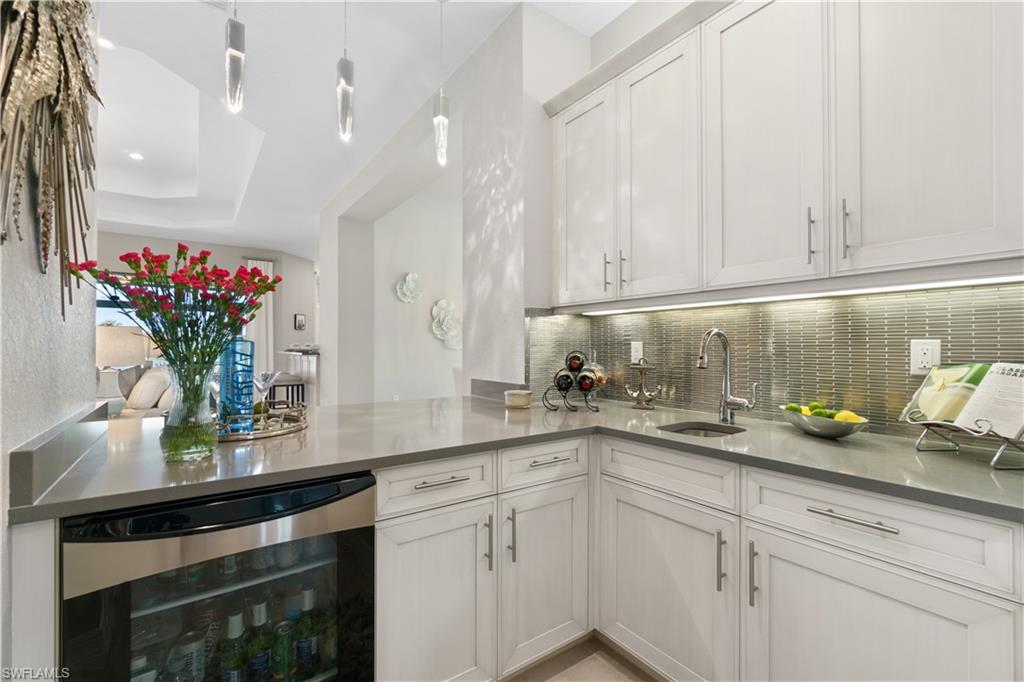 4467 Caldera Circle Naples, FL 34119 - Photo 14 of 50 a kitchen with stainless steel appliances white cabinets and a granite counter tops