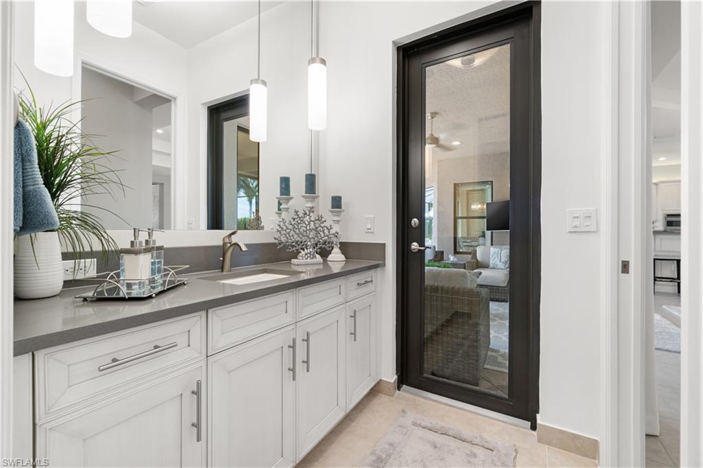 4467 Caldera Circle Naples, FL 34119 - Photo 32 of 50 a bathroom with a granite countertop sink a mirror and a shower