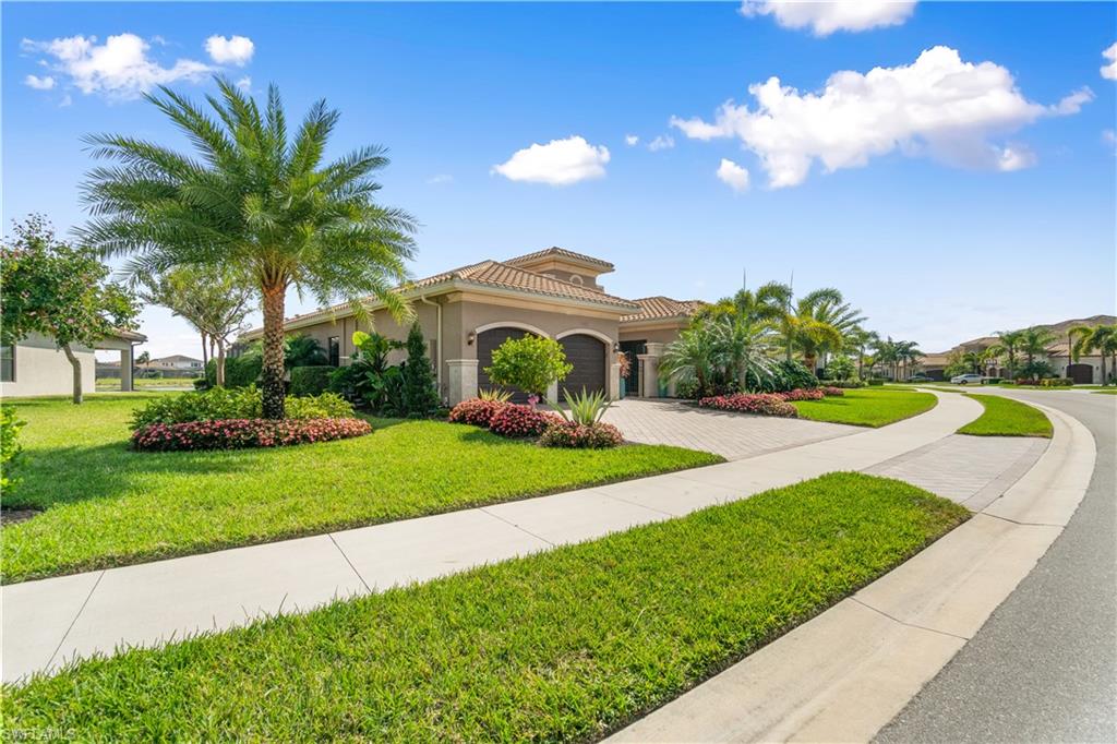 4467 Caldera Circle Naples, FL 34119 - Photo 4 of 50 a front view of a house with a yard and palm trees