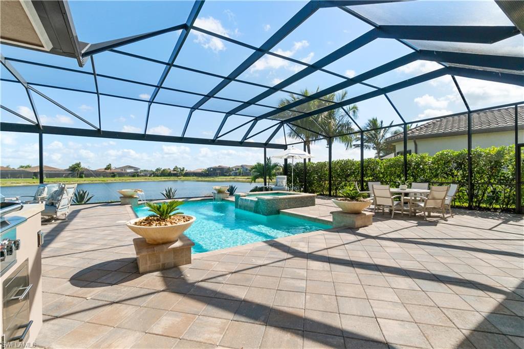 4467 Caldera Circle Naples, FL 34119 - Photo 41 of 50 a view of a patio with a table and chairs under an umbrella