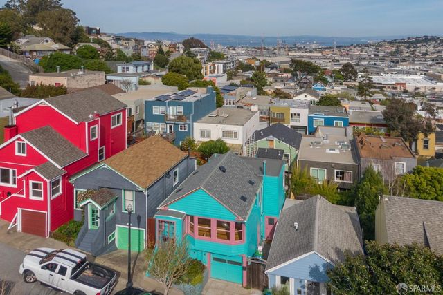 an aerial view of residential houses with outdoor space and parking