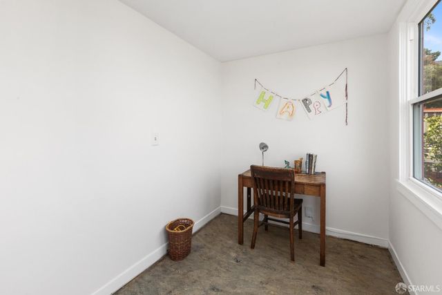 a view of a workspace with furniture and a window