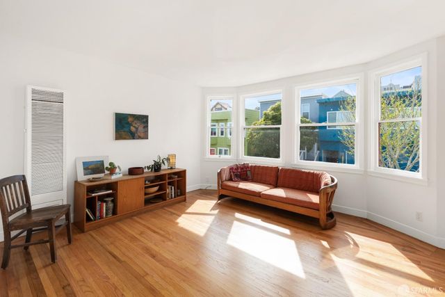 a living room with furniture and a flat screen tv with wooden floor
