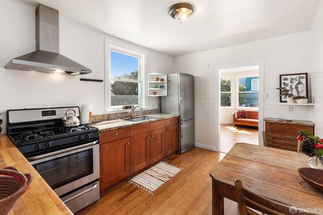 a kitchen with stainless steel appliances a stove a refrigerator and a stove