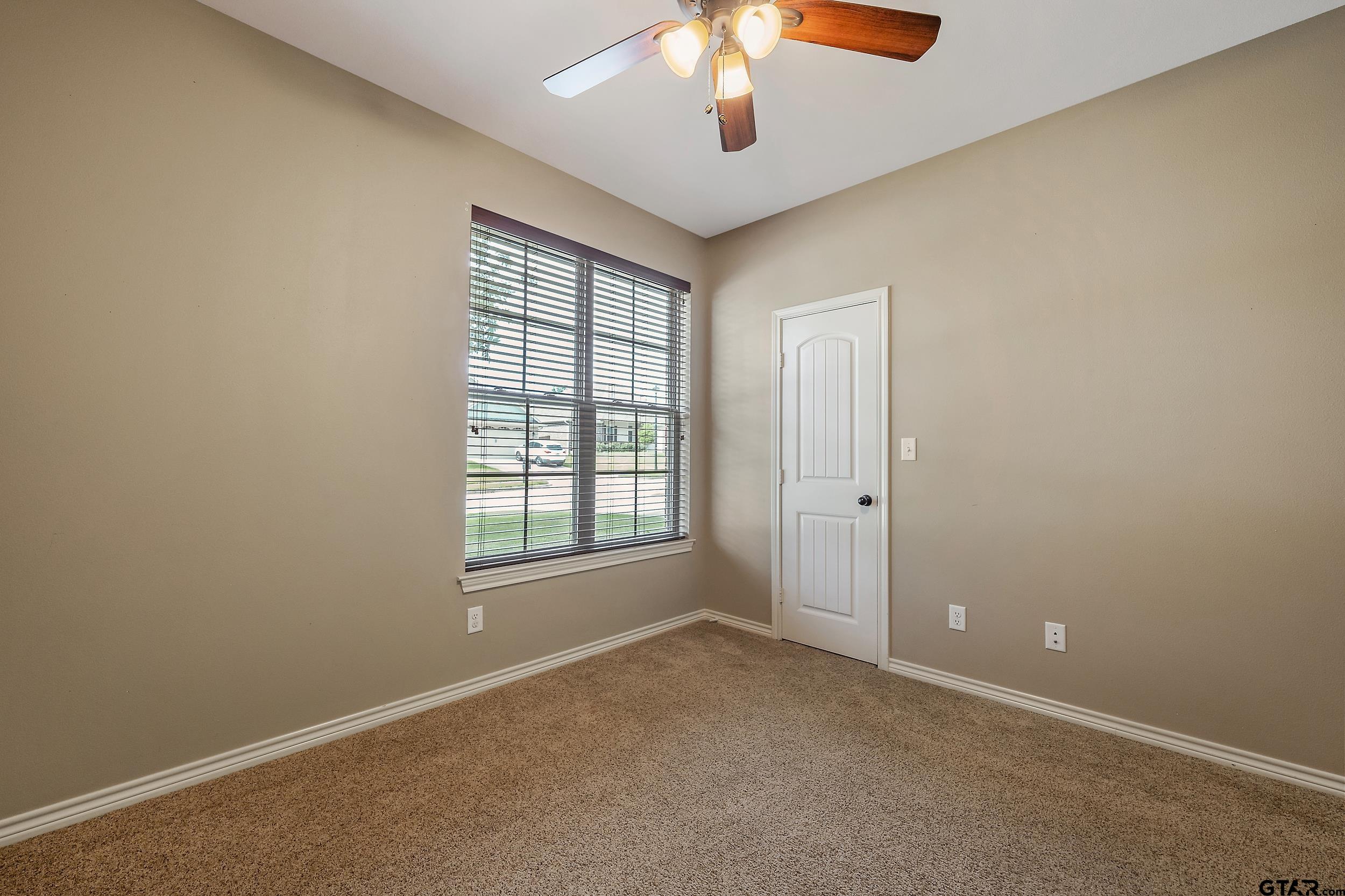5841 Havens Trail Tyler, TX 75707 - Photo 17 of 21 an empty room with chandelier fan and windows