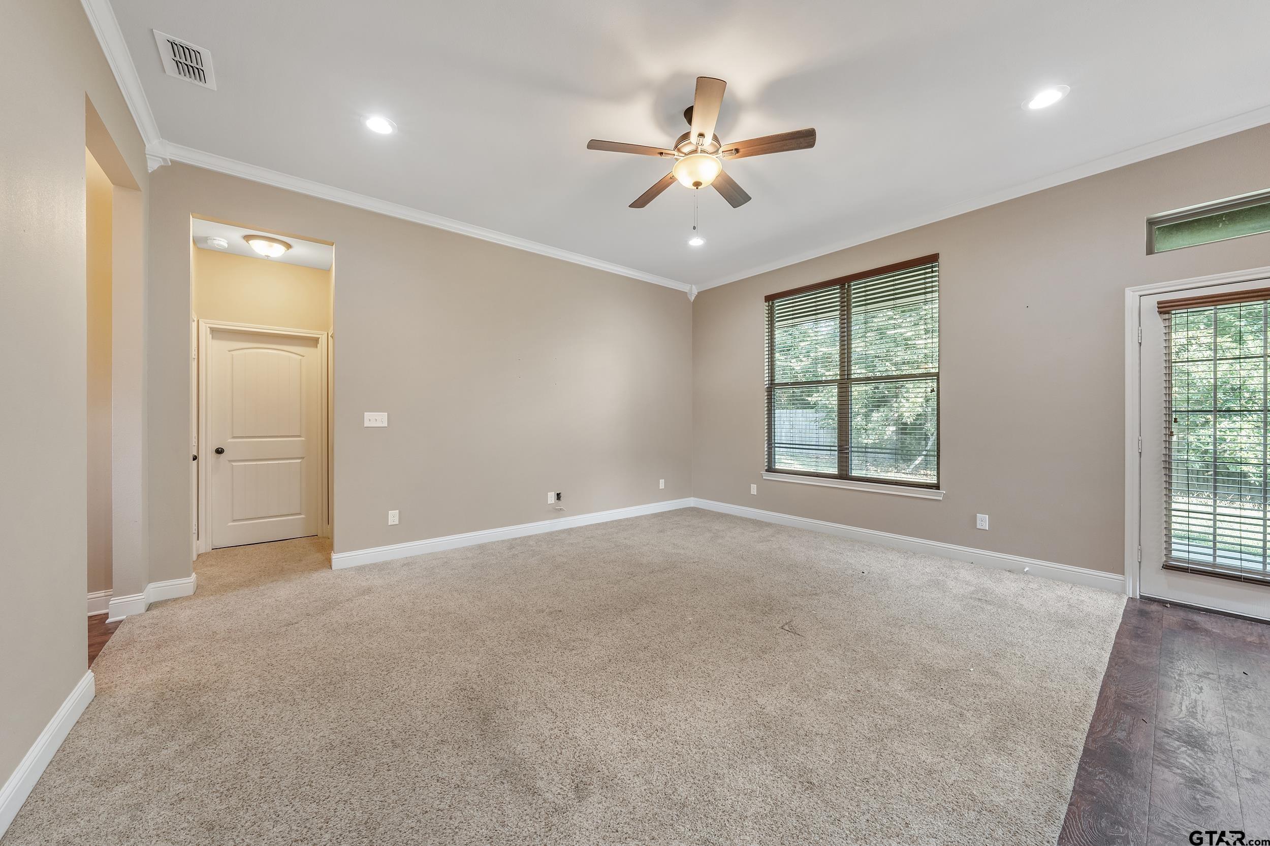 5841 Havens Trail Tyler, TX 75707 - Photo 9 of 21 an empty room with chandelier fan and windows