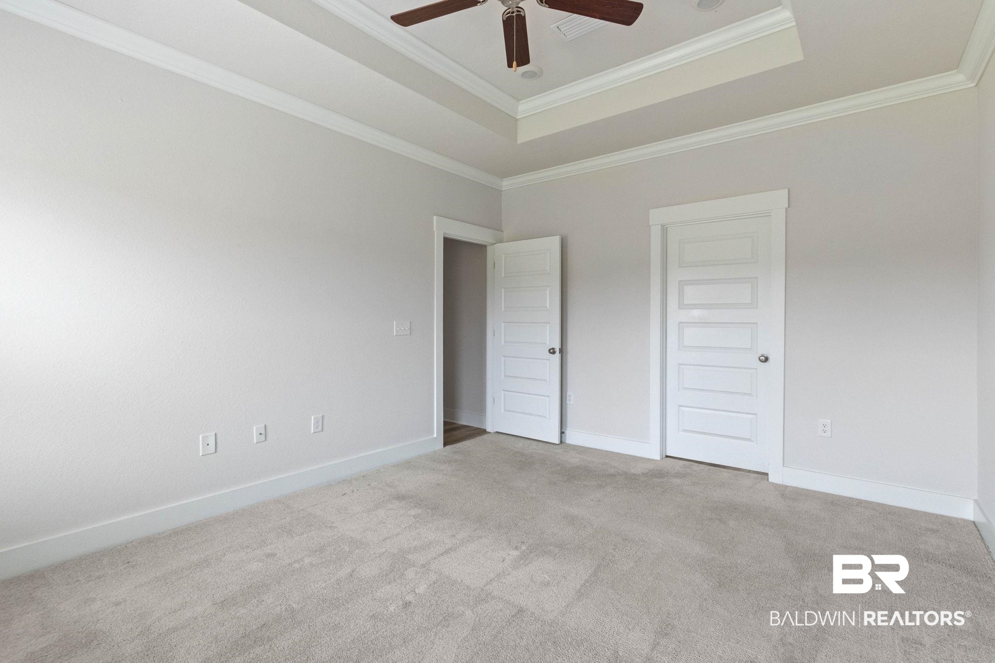 1710 Grouse Street Foley, AL 36535 - Photo 39 of 76 Spacious room featuring neutral carpeting, a tray ceiling with crown molding, and a ceiling fan