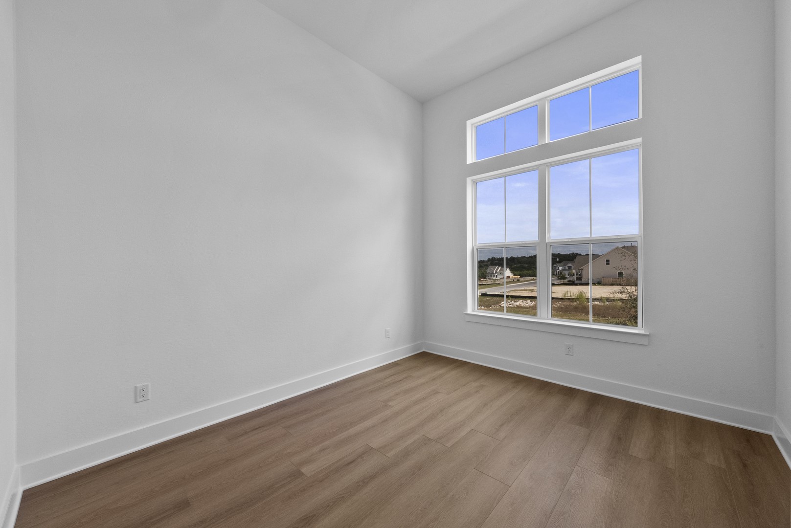 263 Iron Willow Loop Dripping Springs, TX 78620 - Photo 24 of 26 a view of an empty room with wooden floor and fan