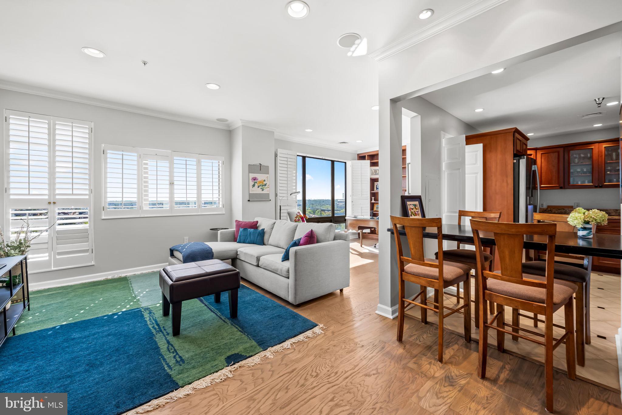 a living room with furniture a dining table and a piano next to a window