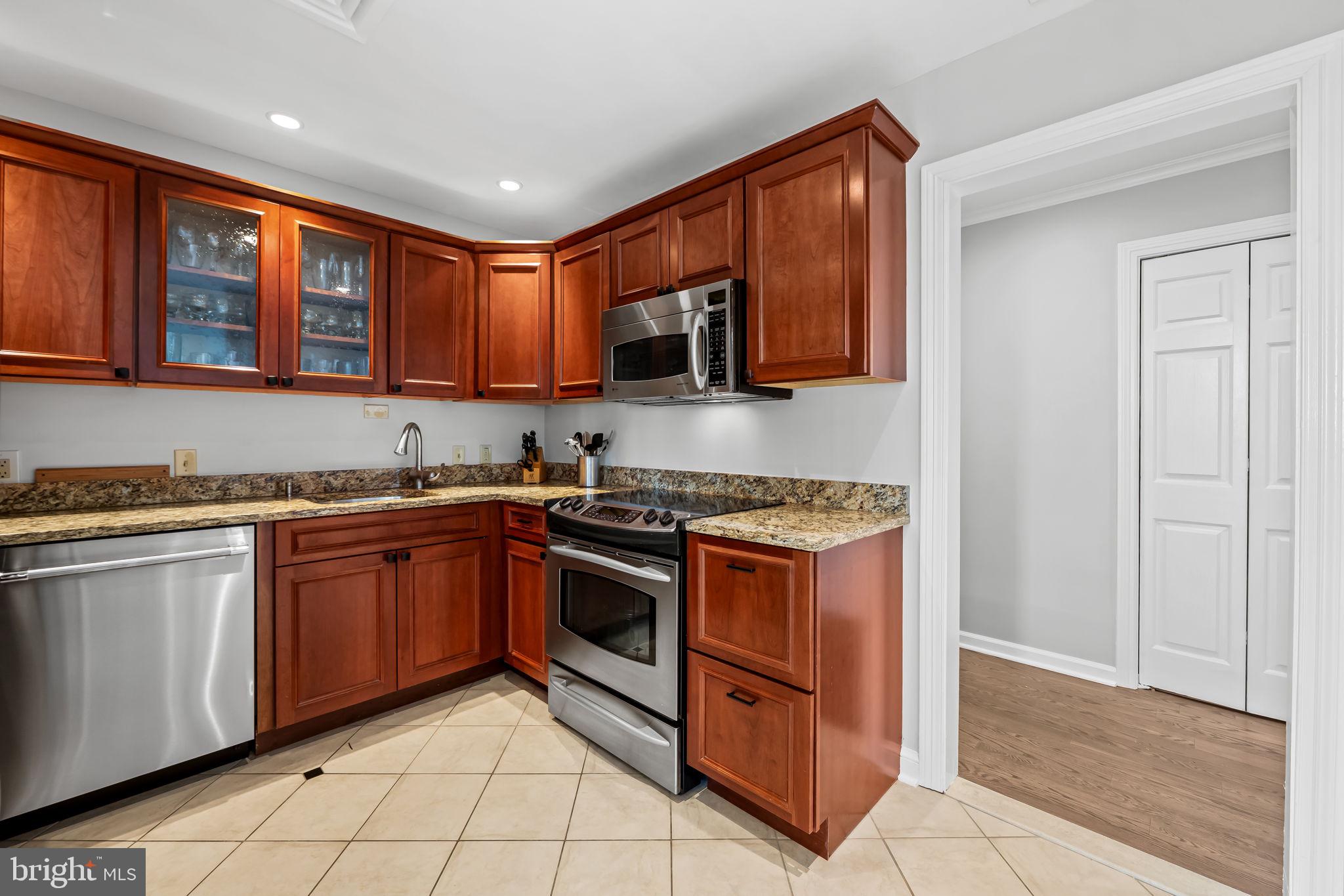 10 East Lee Street, Unit 1103 Baltimore, MD 21202 - Photo 11 of 42 a kitchen with stainless steel appliances granite countertop a stove and a sink