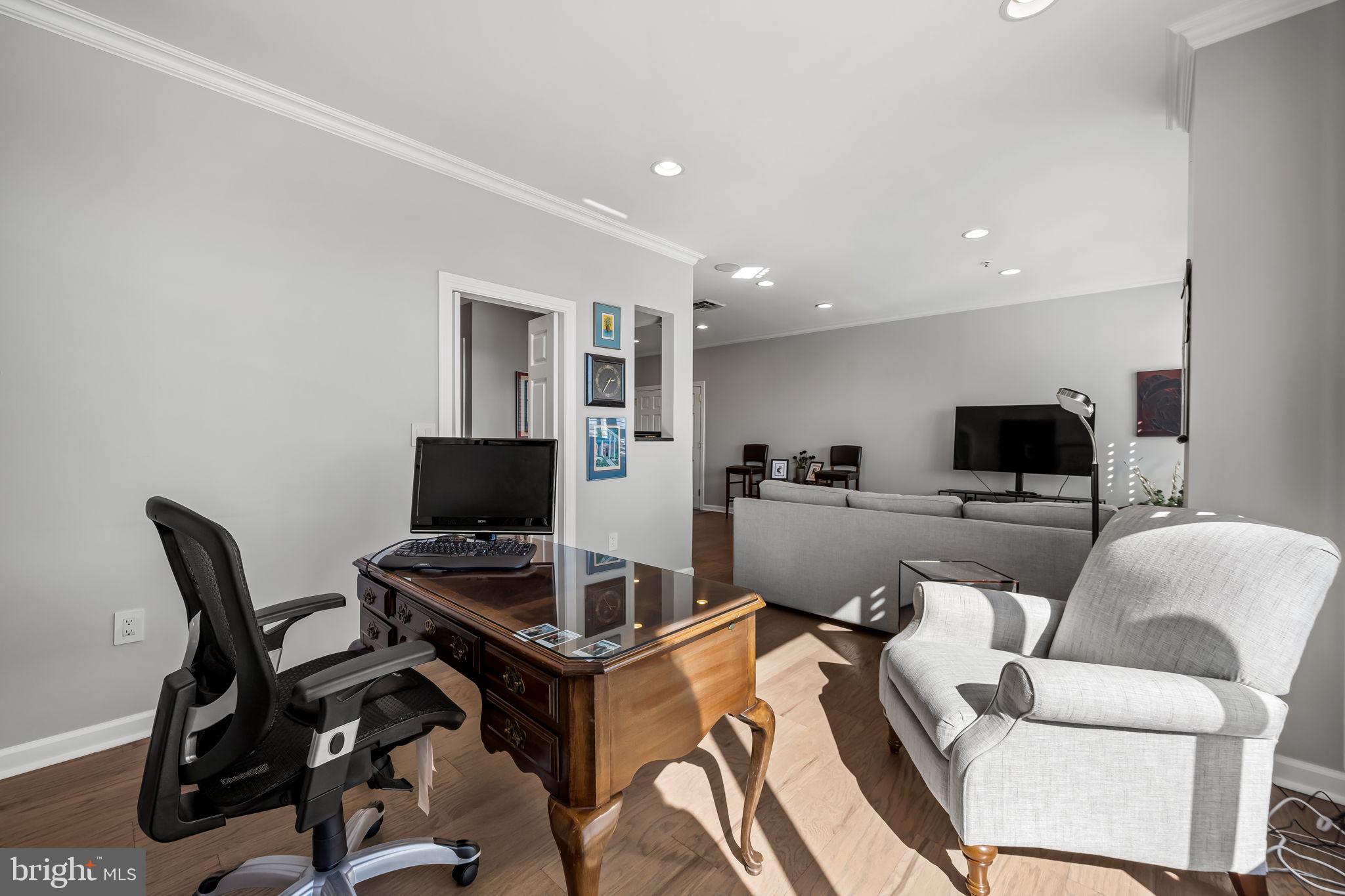 10 East Lee Street, Unit 1103 Baltimore, MD 21202 - Photo 16 of 42 a living room with furniture and a flat screen tv