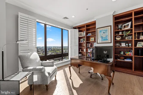 a living room with furniture a bookshelf and a large window