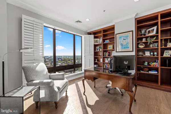 a living room with furniture a bookshelf and a large window