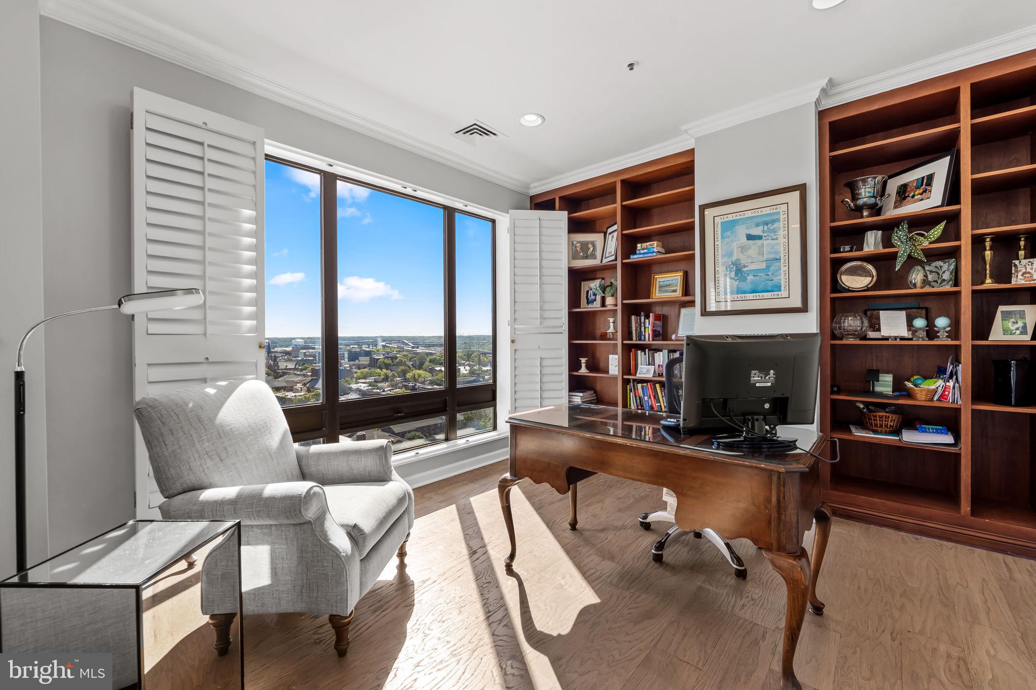 10 East Lee Street, Unit 1103 Baltimore, MD 21202 - Photo 17 of 42 a living room with furniture a bookshelf and a large window