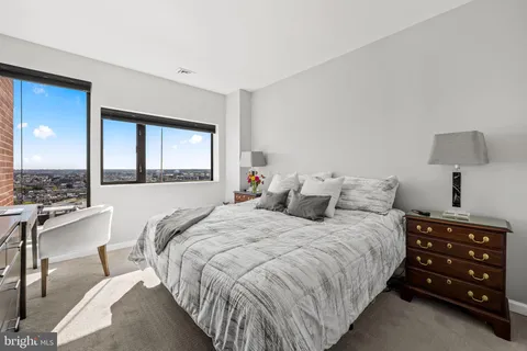 a bedroom with a bed and a mirror on dresser