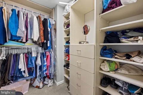 a view of walk in closet with clothes and shoes