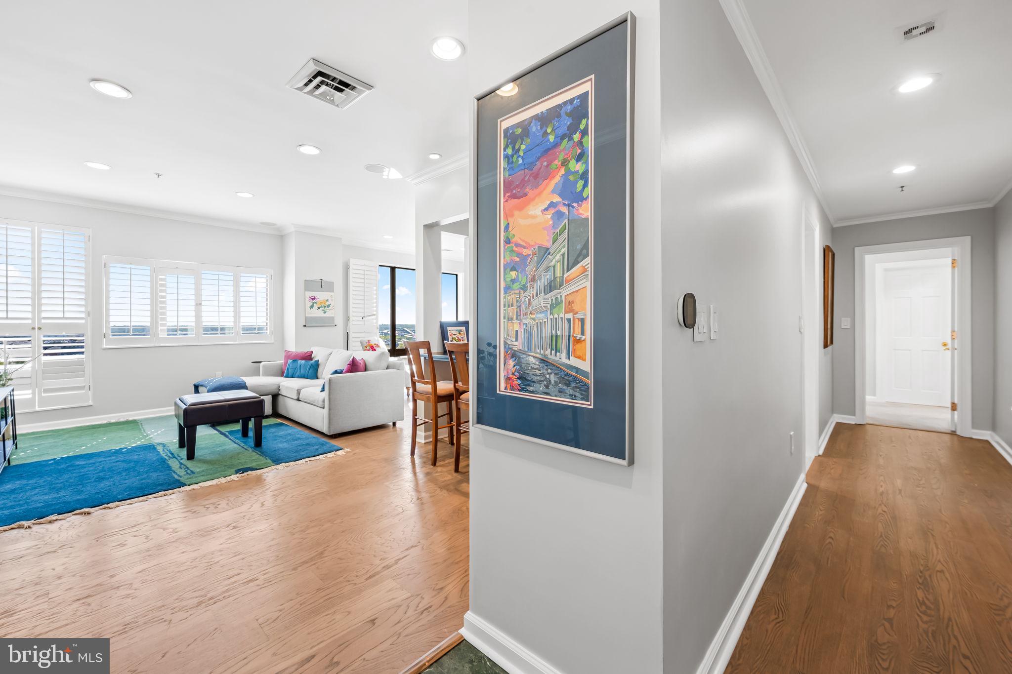 10 East Lee Street, Unit 1103 Baltimore, MD 21202 - Photo 3 of 42 a living room with furniture and a wooden floor