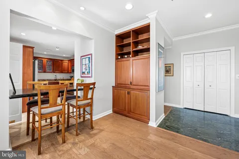 a kitchen with stainless steel appliances kitchen island granite countertop dining table chairs and a refrigerator