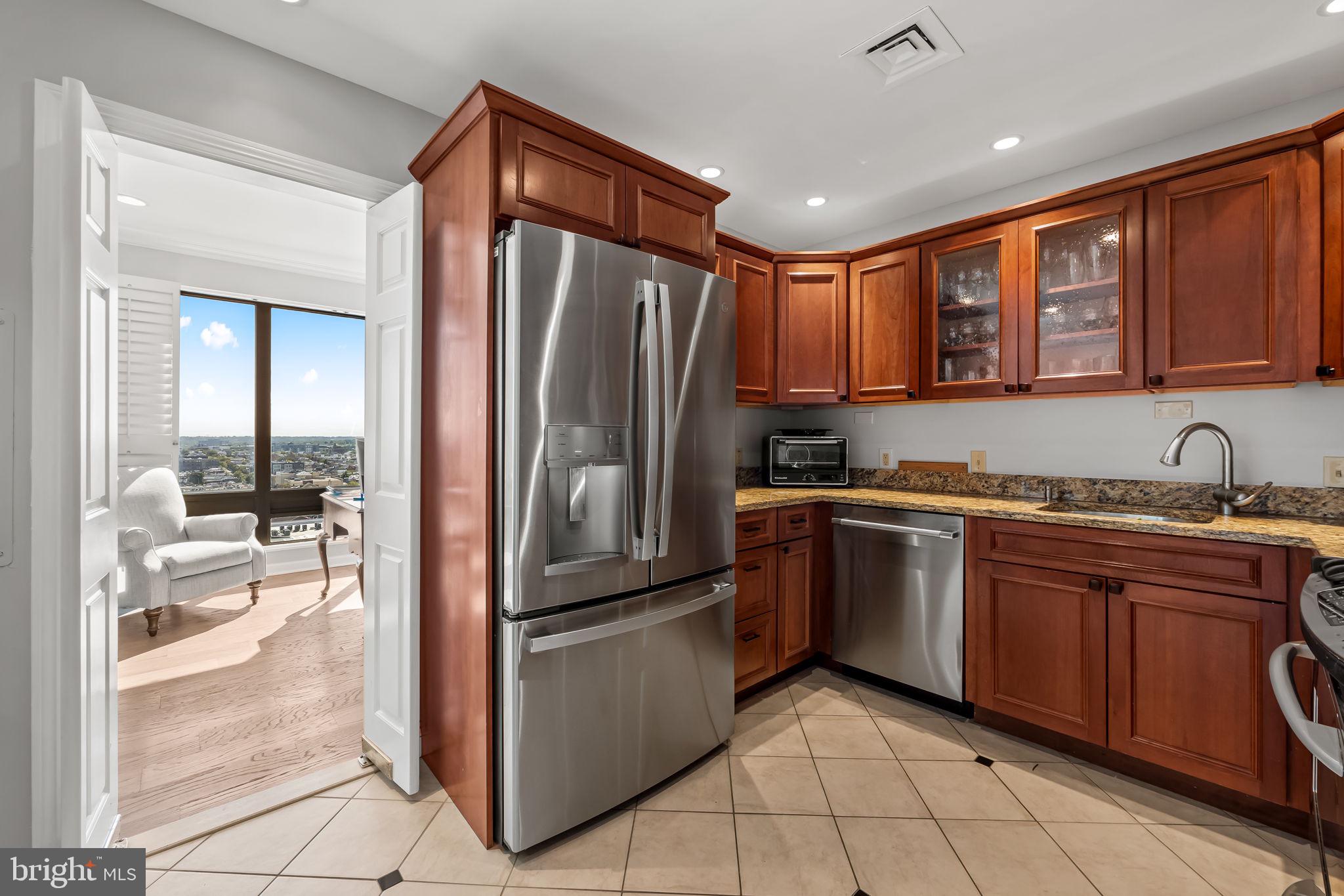 10 East Lee Street, Unit 1103 Baltimore, MD 21202 - Photo 9 of 42 a kitchen with stainless steel appliances granite countertop a refrigerator and a sink