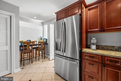 a kitchen with stainless steel appliances granite countertop a refrigerator and a stove top oven