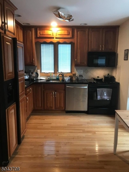 82 Cloverdale Road, Unit 1 Clifton, NJ 07013 - Photo 8 of 12 a kitchen with stainless steel appliances granite countertop a stove a sink and a refrigerator