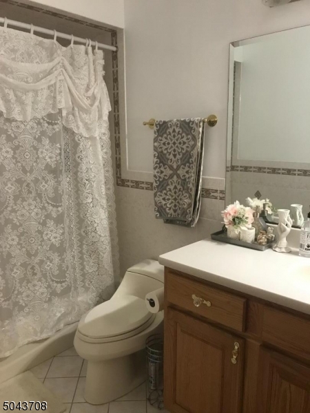 82 Cloverdale Road, Unit 1 Clifton, NJ 07013 - Photo 10 of 12 a bathroom with a granite countertop sink a toilet and a shower