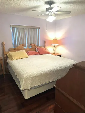 a bed sitting in a bedroom next to a window and a chandelier