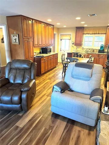 a living room with furniture kitchen area and a large window