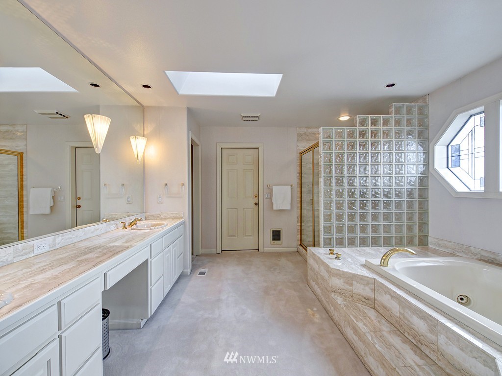 7023 Ripley Lane North Renton, WA 98056 - Photo 13 of 15 a spacious bathroom with a granite countertop tub shower double vanity and a mirror