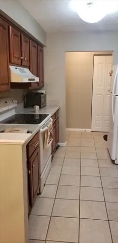 a kitchen with a stove top oven cabinets and a refrigerator