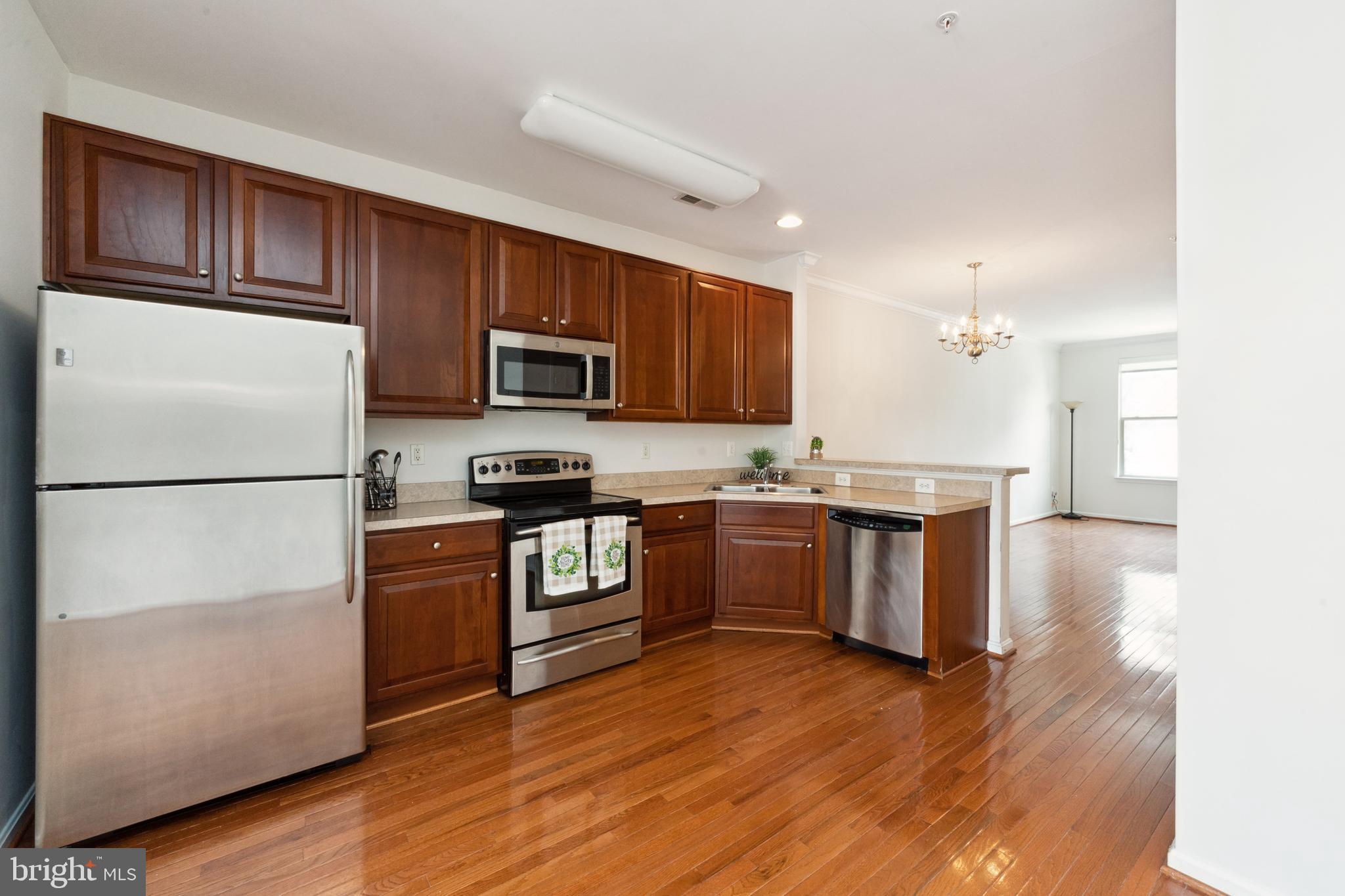 17 South Exeter Street, Unit 161 Baltimore, MD 21202 - Photo 3 of 27 a kitchen with granite countertop wooden floors stainless steel appliances and a sink