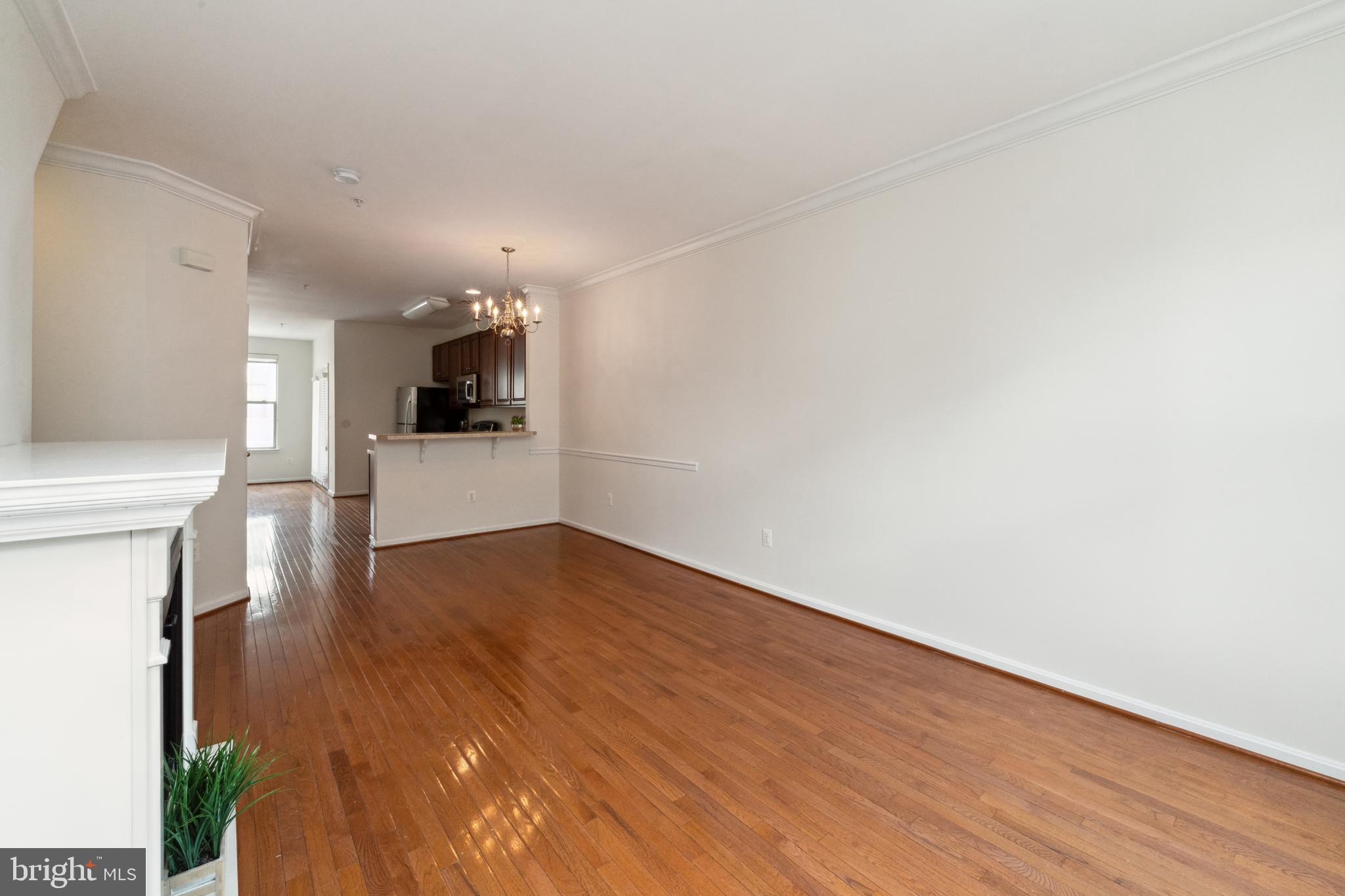 17 South Exeter Street, Unit 161 Baltimore, MD 21202 - Photo 7 of 27 a view of a kitchen and an empty room with wooden floor
