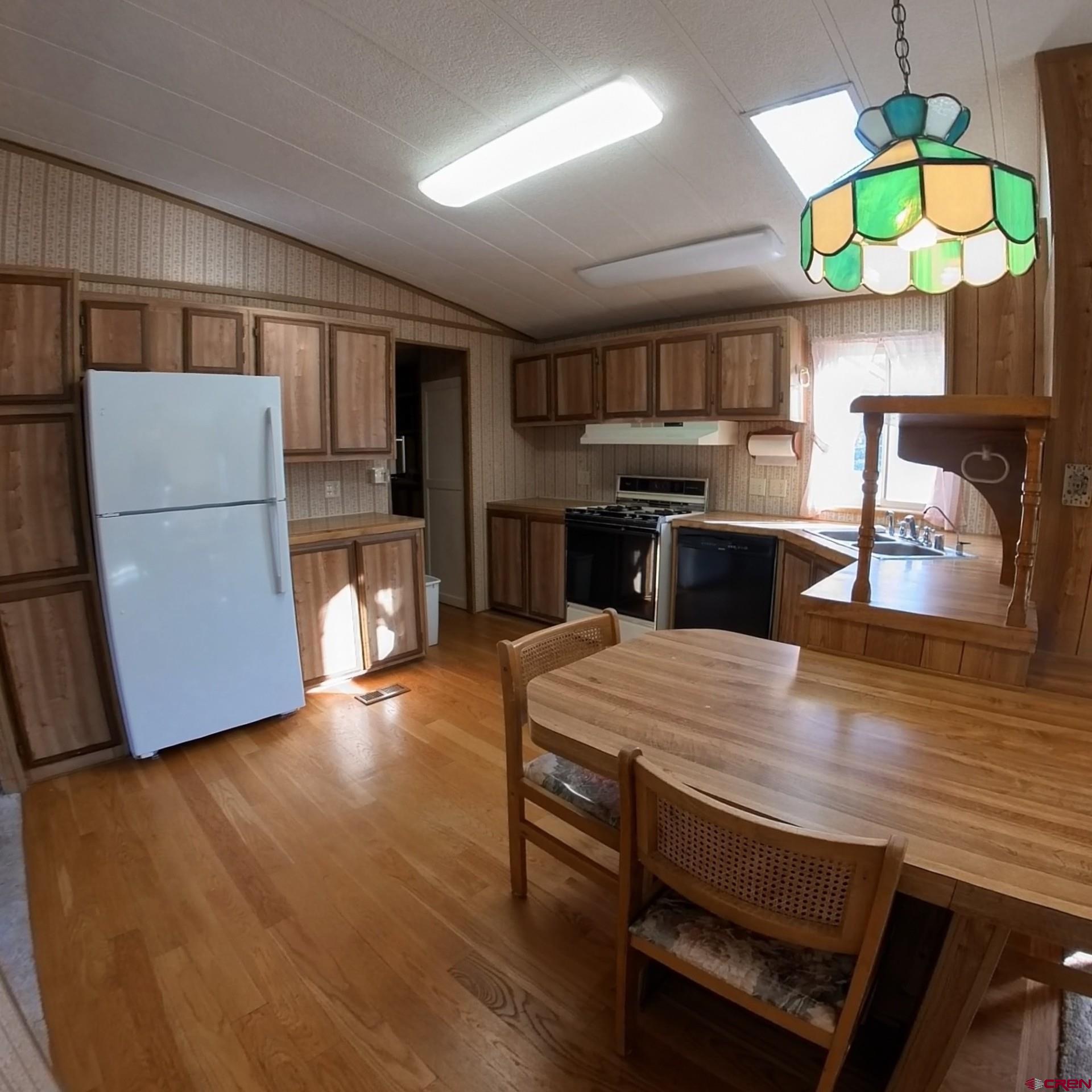 18865 Northridge Road Cedaredge, CO 81413 - Photo 9 of 23 a kitchen with stainless steel appliances granite countertop a stove refrigerator and a dining table with wooden floor