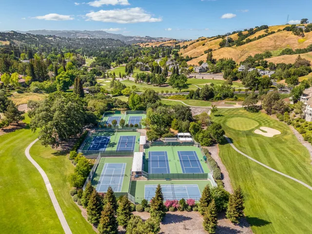 an aerial view of residential houses with outdoor space and swimming pool