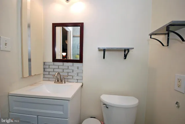 a bathroom with a toilet a sink and mirror