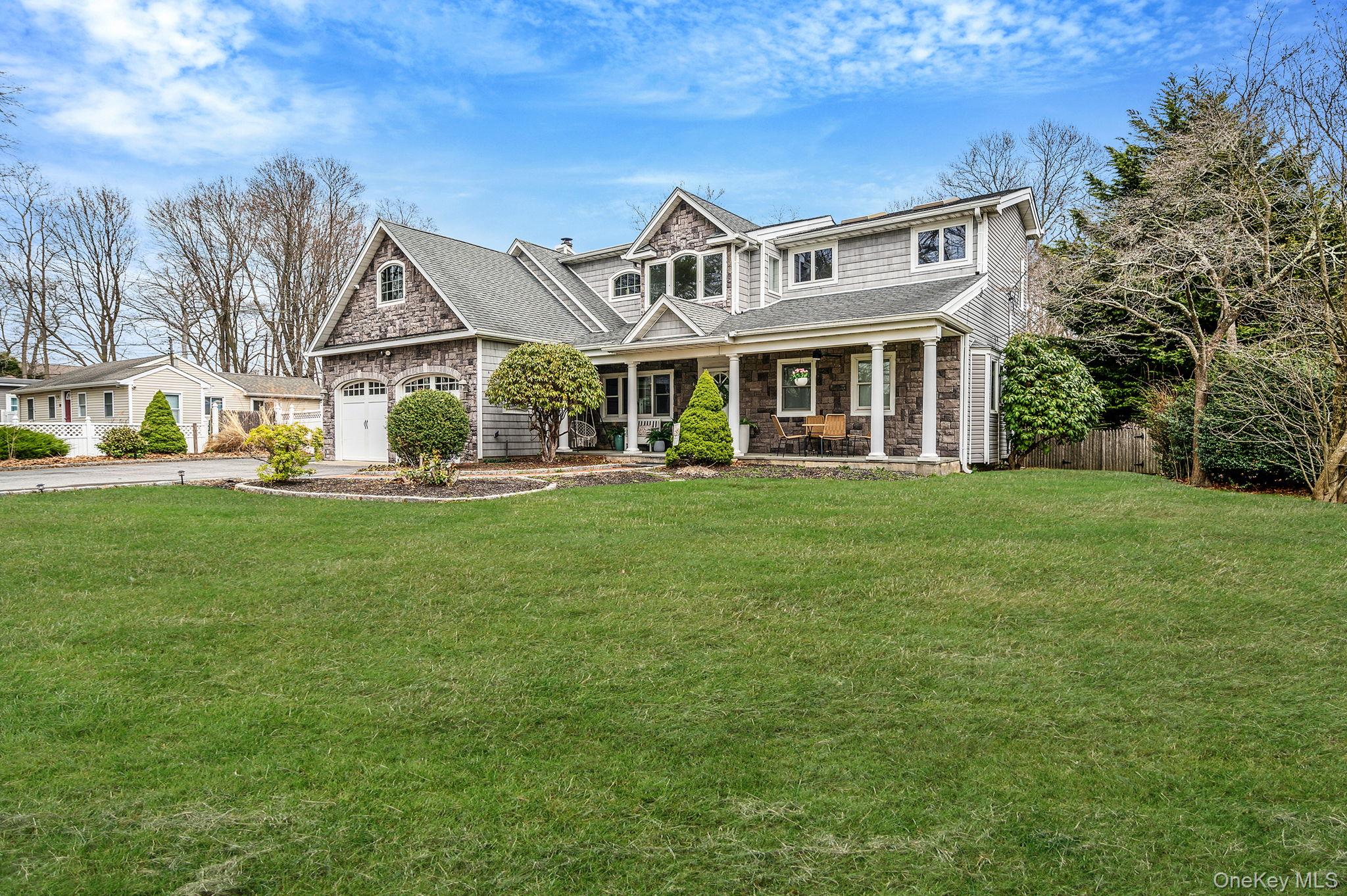 23 Wylde Road Mount Sinai, NY 11766 - Photo 3 of 45 a front view of a house with a garden and trees