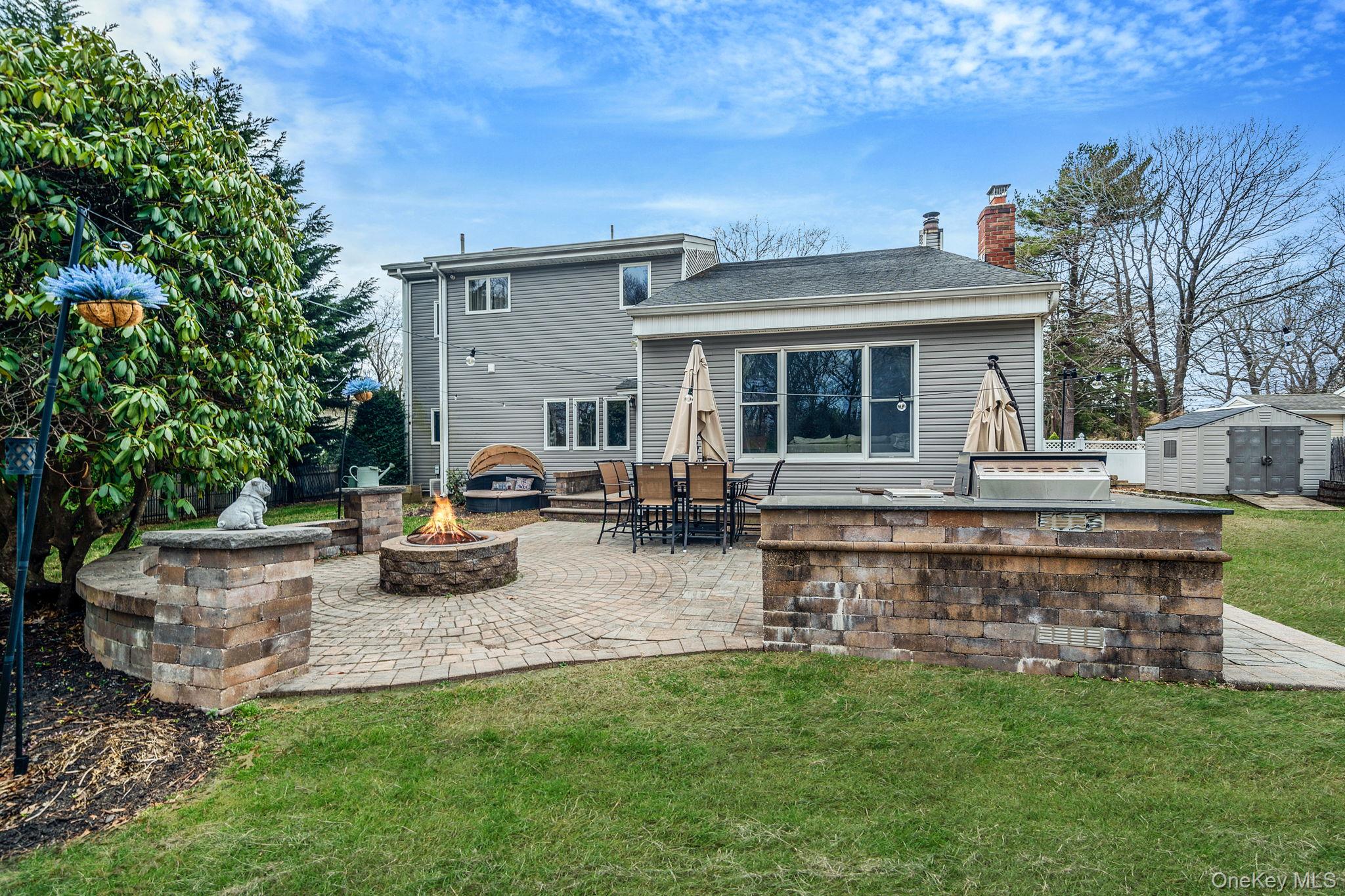 23 Wylde Road Mount Sinai, NY 11766 - Photo 37 of 45 a view of a house with patio and a garden