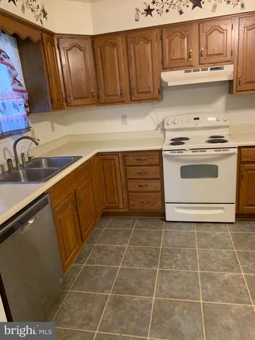 a kitchen with a sink a refrigerator and cabinets