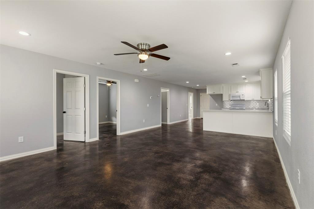 933 Rice Street Denison, TX 75020 - Photo 4 of 19 a view of an empty room with a kitchen