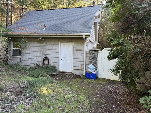 a view of brick house with small yard and large tree