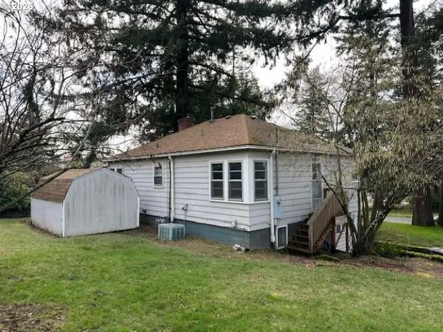 a view of a house with a backyard and a tree