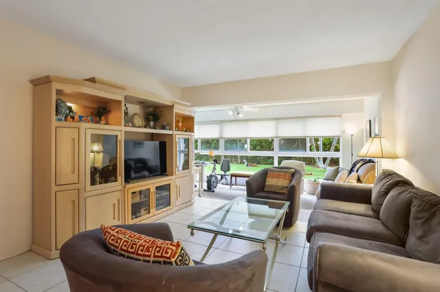 a living room with furniture a flat screen tv and a large window