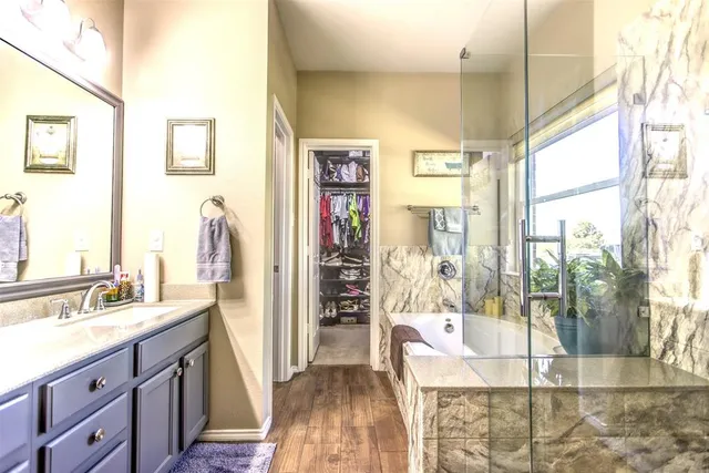a spacious bathroom with a double vanity sink a mirror and next to a window