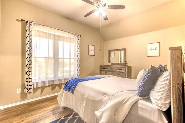 a bedroom with a large bed and a chandelier