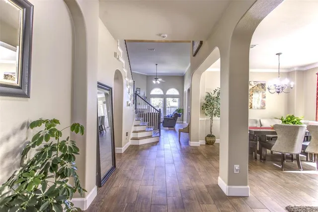 a hall way with furniture and a potted plant