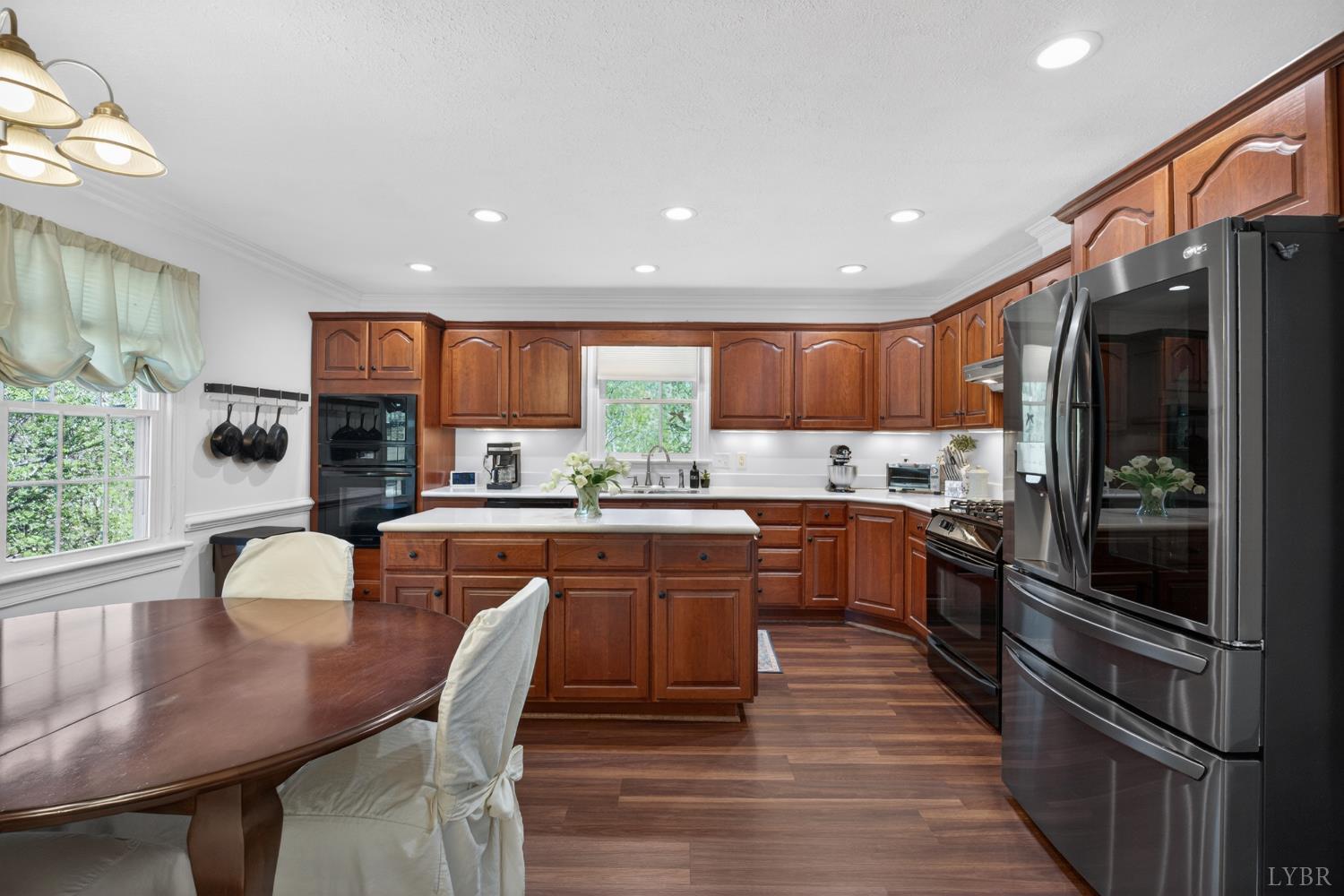 316 Quail Ridge Drive Forest, VA 24551 - Photo 8 of 35 a kitchen with stainless steel appliances granite countertop a refrigerator a stove top oven a sink dishwasher a dining table and chairs with wooden floor