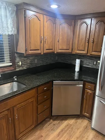 a kitchen with granite countertop stainless steel appliances a sink and cabinets