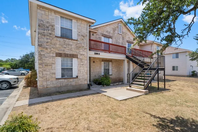 a view of house with backyard and a tree
