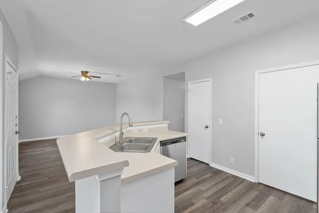 a kitchen with a sink cabinetry and wooden floor