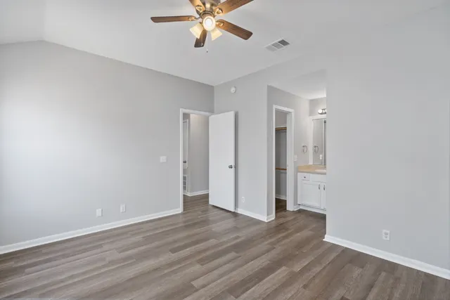 a view of an empty room with wooden floor